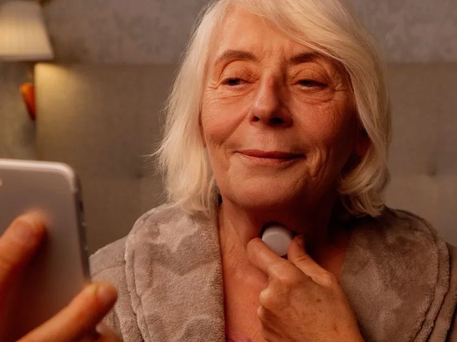 A woman using the Sámh sleep sensor with the guided mobile app